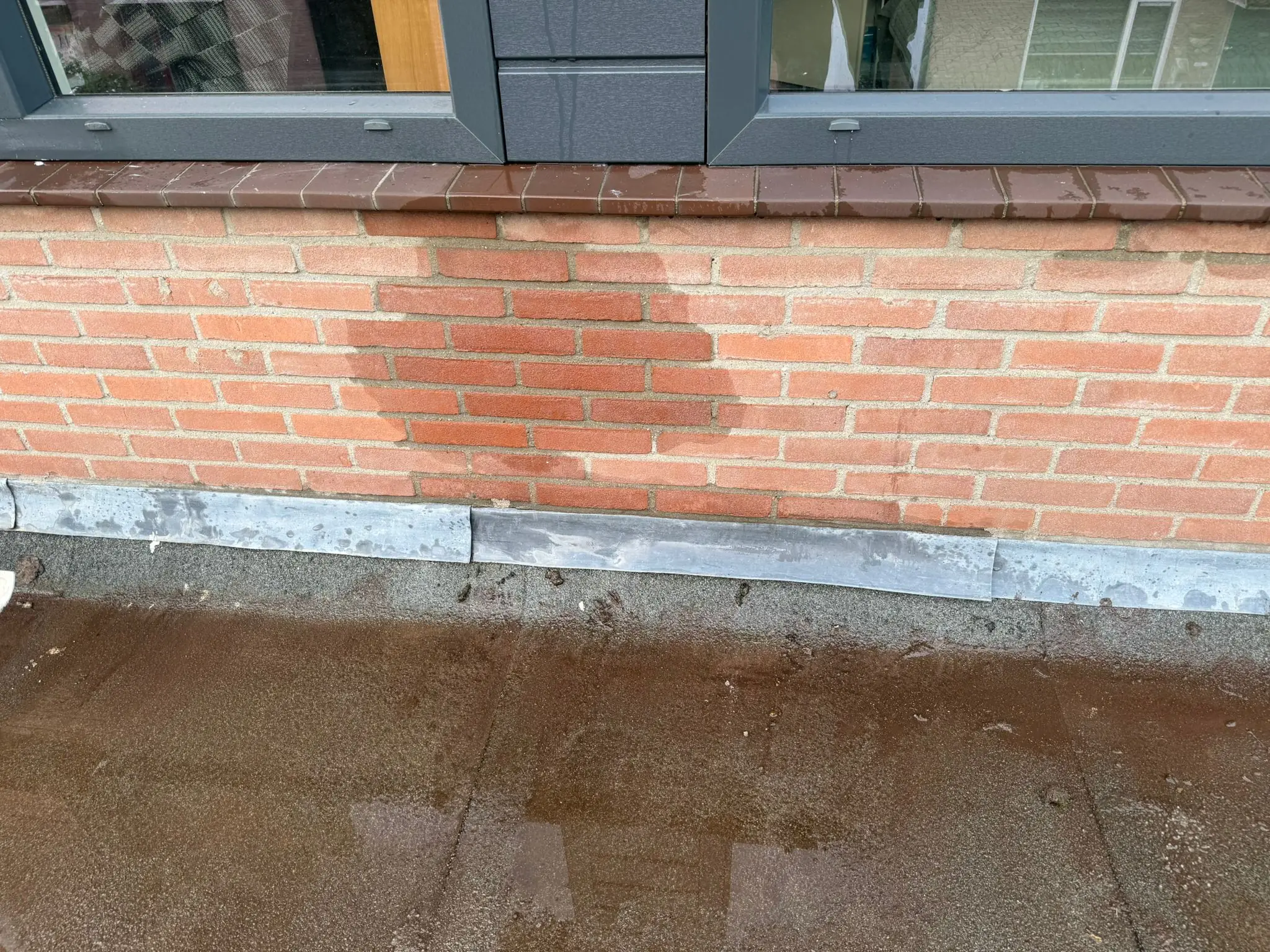 Slagregen op pannendak bij sterke westenwind die lekkage veroorzaakt